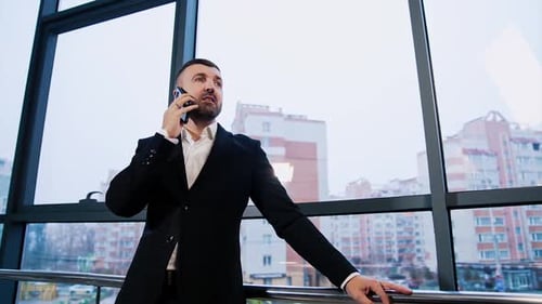Man in Suit Talking on Phone in Modern Office