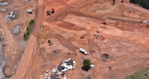 Eine Luftaufnahme einer großen Baustelle, auf der Erdbewegungsmaschinen, schwere Maschinen und Traktoren
