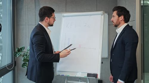 Businessmen Analyzing KPI Data in Office Meeting