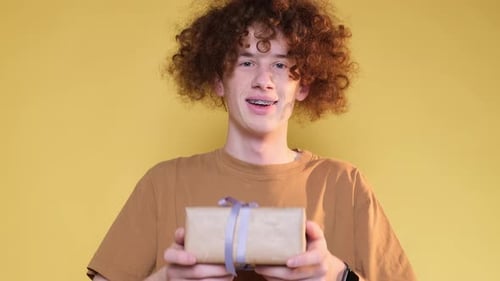Teen Smiling and Holding Birthday Present