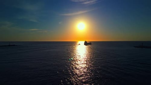 Experience the Tranquility of a Sunset Over the Sea Capturing a Boats Silhouette in an Aerial View