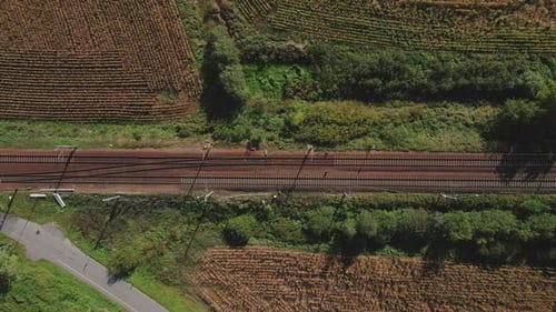 Luftaufnahme von Bahngleisen durch grüne Landschaft
