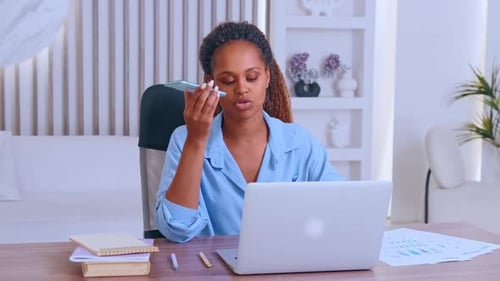Young African American Woman Entrepreneur Talking on Phone Sits in Office