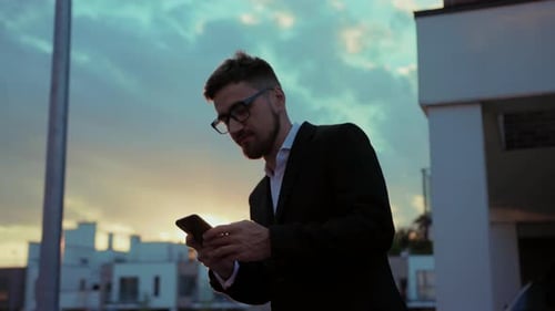 Ein Mann im Anzug konzentriert sich auf sein Handy und verbindet Geschäft und Technologie