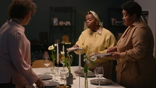 Women Preparing Table for Dinner Party at Home