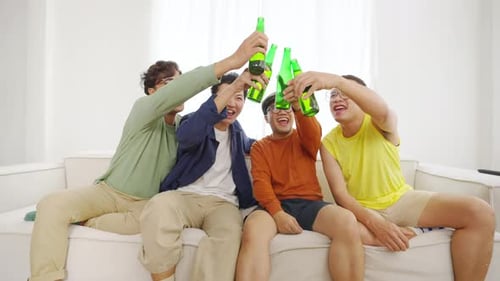 Friends Celebrating Together with Beer on the Sofa