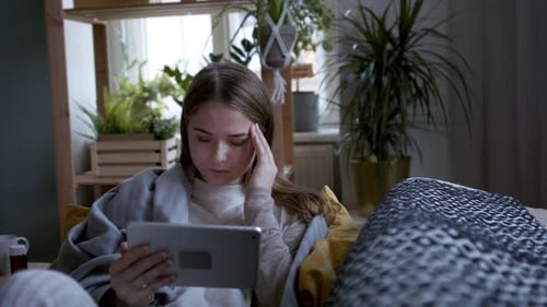 Woman with Headache Uses Tablet in Bright Home