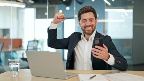 Excited business man celebrates success in office