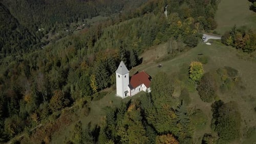 Aerial view of church, mountain, trees in autumn, Slovenia.