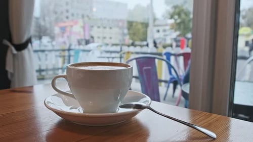 Tasse de café sur la table dans un café en face de la fenêtre donnant sur la rue