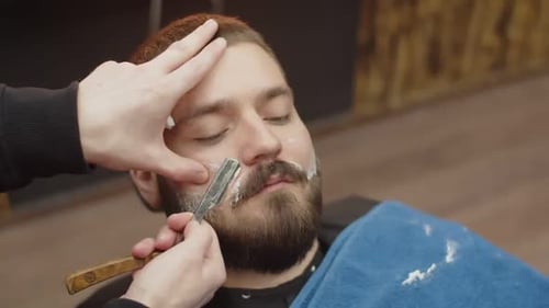Man Getting Beard Shaved by Barber