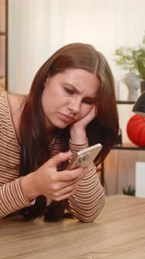 Woman Looks Bored Using Phone Indoors Resting Head