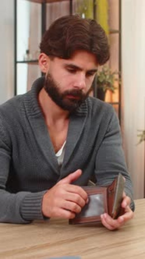 Man Counting Money from Wallet at Table