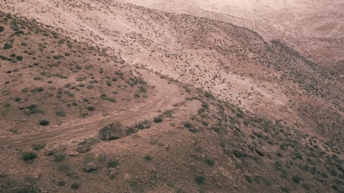 Sentier de terre sinueux à travers le paysage aride du Pamir au Tadjikistan