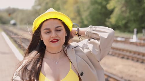 Young Woman Posing near Railroad Tracks in Sunlight