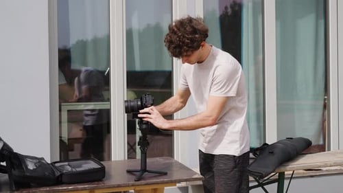 Male attach camera on gimbal stabilizer near reflective building window