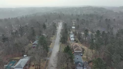 Aerial view of windy snowstorm in american suburb neighborhood. Snowy flurries during cloudy day in