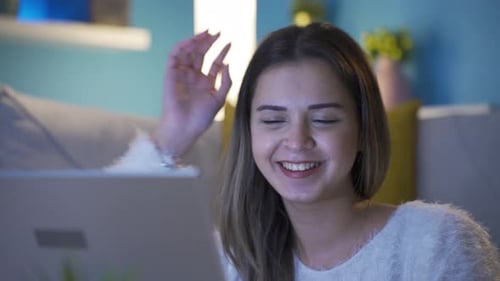 Young Woman Smiling While Using Laptop At Home