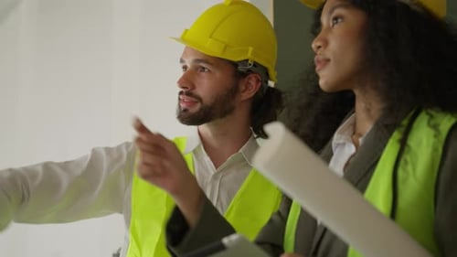 Engenheiros usando o tablet conversando e fazendo brainstorming juntos no canteiro de obras