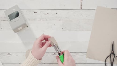 Hands Crafting Gift Tags With Hole Punch