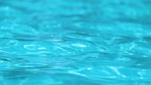 Closeup Surface of Blue Clear Water with Small Ripple Waves in Swimming Pool