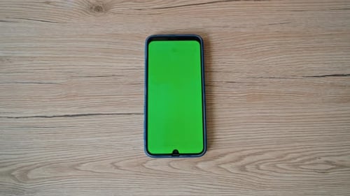 Smartphone User Zooming Green Screen Watching App at Home Table Closeup