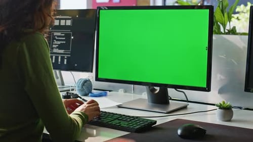 Woman Typing at Computer With Green Screen Monitor
