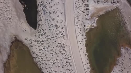 Vue aérienne sur une route sablonneuse dans le désert entourée de petits lagons