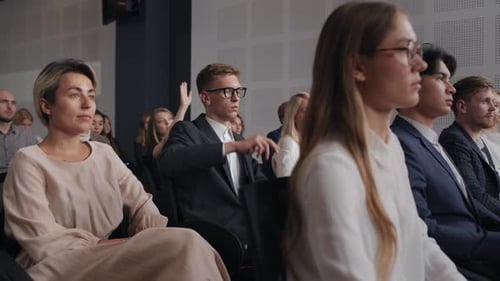 Attendees raise hands at a corporate conference in city
