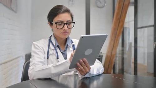 Woman doctor interacting with tablet in office