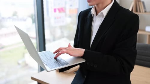Businesswoman Using Laptop in Modern Office Environment