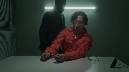 Man in Jumpsuit Interrogated at Table