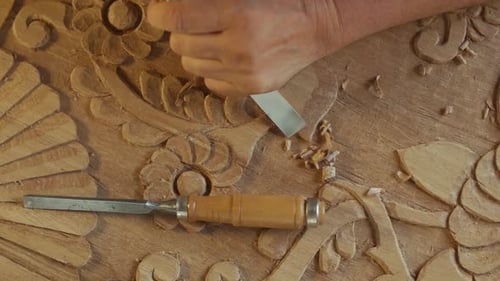the carpenter carves and shapes the wood. close-up shot. The camera shoots a close-up of the hands c