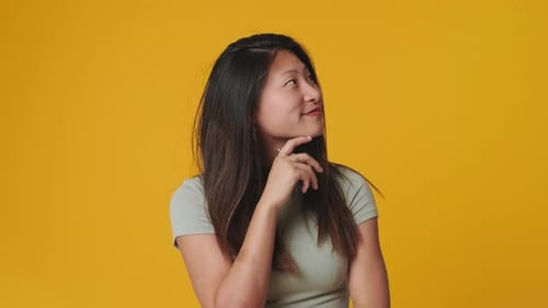 Young woman doubt and thinking with confusion isolated over yellow background in studio