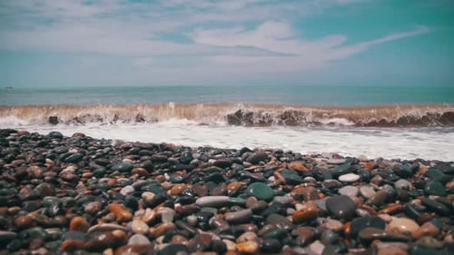 Sturm auf dem Meer Die Wellen rollen an einem Kieselsteinstrand Zeitlupe