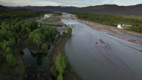 Drone flies above majestic mountains forest and river near jackson hole Wyoming