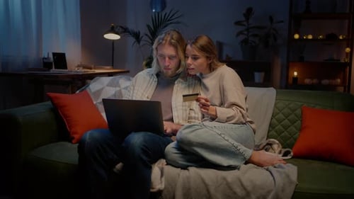 Couple Shops Online From Sofa at Night