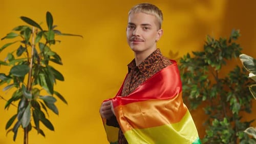 Person Smiling Wrapped in a Pride Flag in Studio