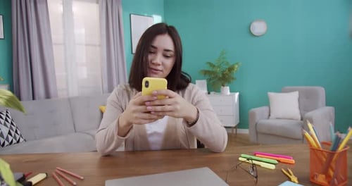 Young Woman Using Smartphone at Home