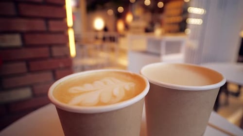 Close Up Two Cardboard Coffee Cups Take Away on Table Over Bokeh Background Coffee Shop and Take