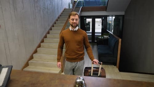 Businessman Checking Into Hotel at Reception Desk