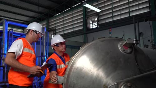 Factory Workers Discussing Machinery