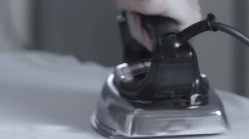 Ironing clothes to remove wrinkles - isolated close up