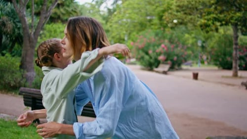 Mother Daughter Holding Hands Looking Each Other at Greenery Park Nature Closeup