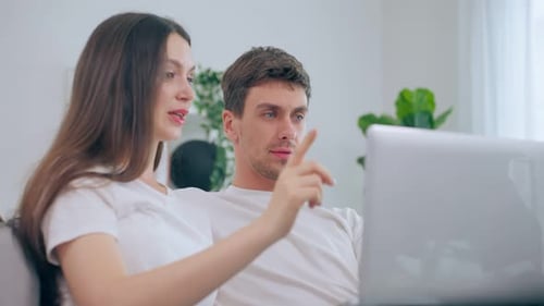 Couple Browsing Laptop Together on Couch at Home
