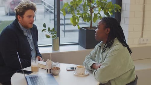 Man and Woman in Cafe Having Conversation