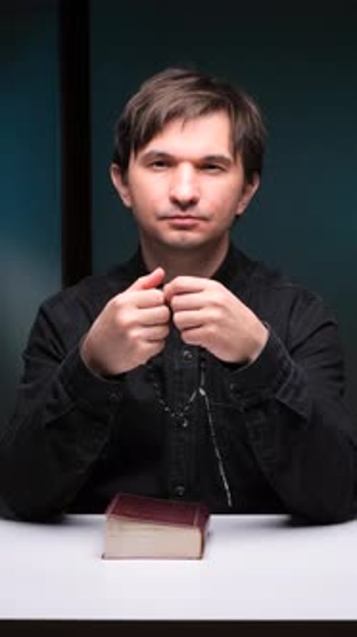 Vertical Video Priest Praying with Rosary and Bible on White Table