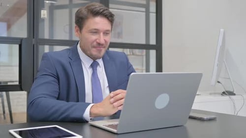 Man in Suit Video Calling at Office Desk