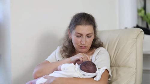 Loving Mother Cradling Infant in Home Setting