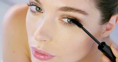 Young Adult Woman Applying Mascara Close Up